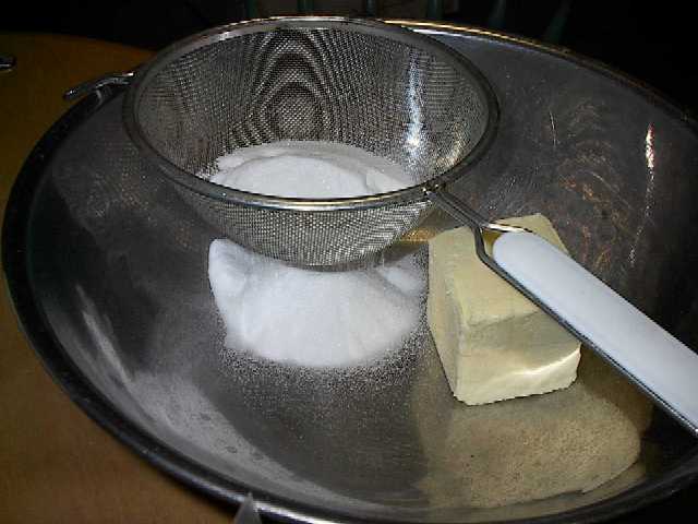 In a mixing bowl, a block of butter and sifted sugar